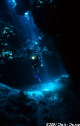Diver in sunrays ina cave by Dieter Decroos 